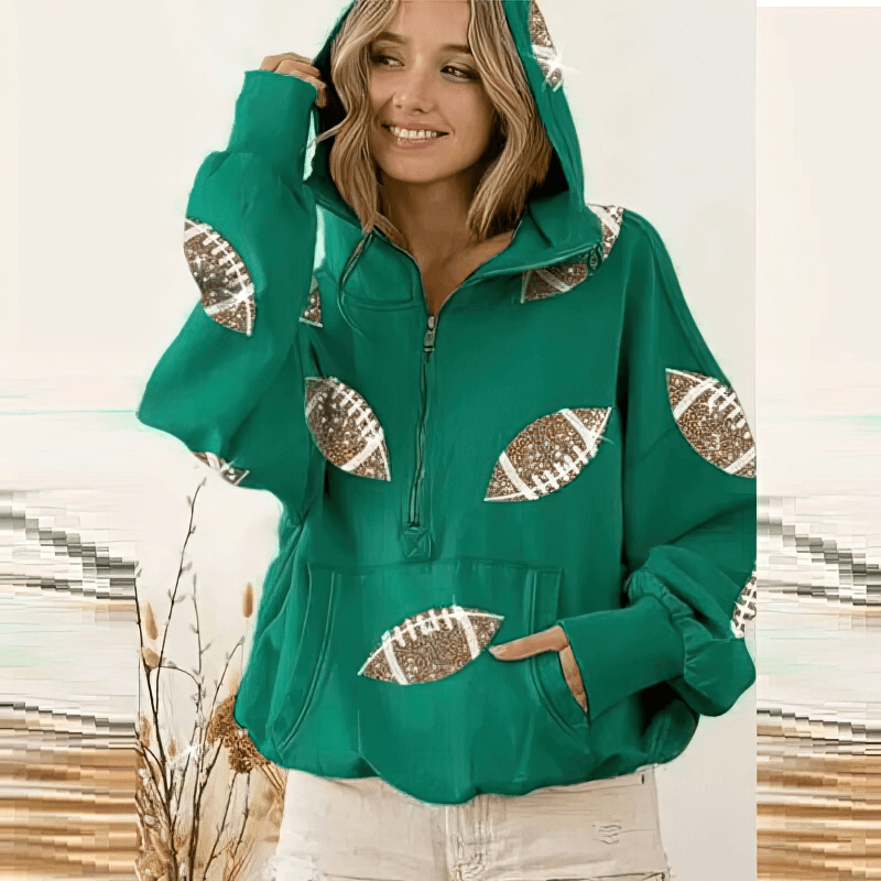 Sporty casual women's hoodie with sequined footballs, front pockets, and hood, in vibrant green, model smiling and posing.